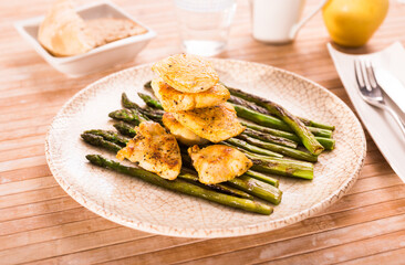fried chicken breast pieces with asparagus on white plate