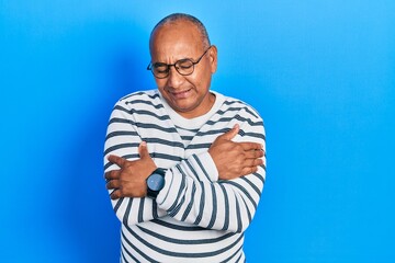 Naklejka premium Middle age latin man wearing casual clothes and glasses hugging oneself happy and positive, smiling confident. self love and self care