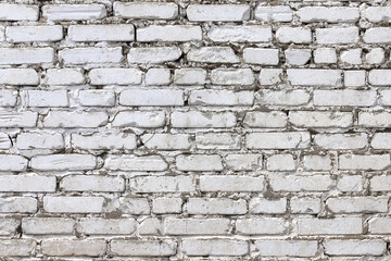 An old damaged wall made of white bricks as a background