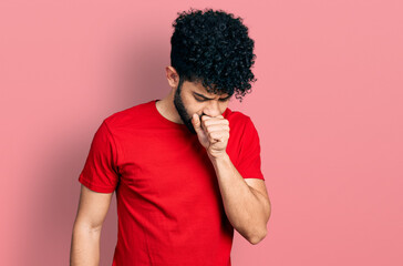 Young arab man with beard wearing casual red t shirt feeling unwell and coughing as symptom for cold or bronchitis. health care concept.