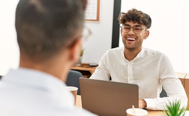 Obraz premium Two hispanic men business workers smiling confident working at office