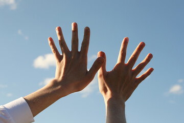 Young man hands and blue sky. Photo was taken 22 May 2022 year, MSK time in Russia.