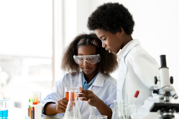 Two african american cute little boy and girl student child learn science research and doing a...