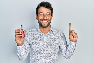 Handsome man with beard football reporter holding electronic cigarette smiling with an idea or...