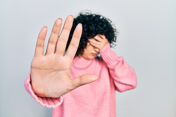 Young middle east woman wearing casual clothes covering eyes with hands and doing stop gesture with sad and fear expression. embarrassed and negative concept. - obrazy, fototapety, plakaty