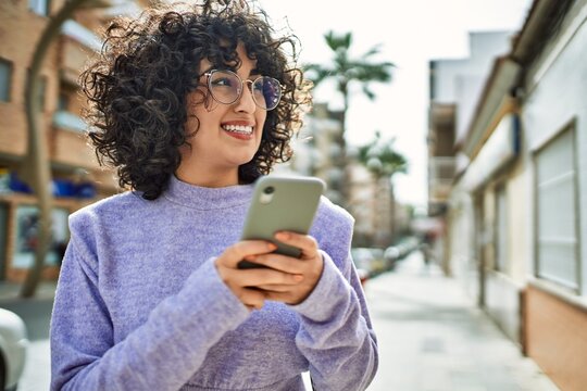Young middle east woman smiling confident using smartphone at street