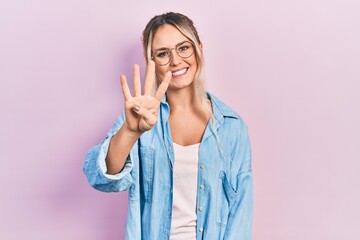 Beautiful young blonde woman wearing casual clothes and glasses showing and pointing up with...