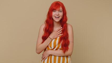 Joyful redhead woman laughing out loud after hearing ridiculous anecdote, funny joke, feeling carefree amused, positive people lifestyle. Young ginger girl isolated alone on beige studio background