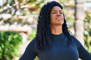 African american woman smiling confident breathing at park