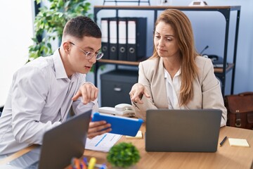 Man and woman business workers using laptop and touchpad working at office