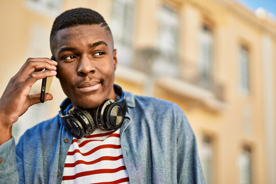 Young african american man with serious expression talking on the smartphone at the city.