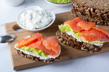 Healthy toasts with rye bread with cream cheese, salmon and salad