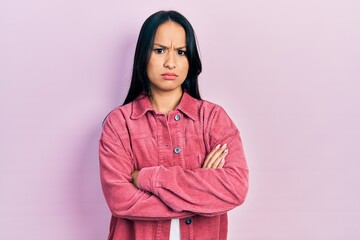 Beautiful hispanic woman with nose piercing wearing casual pink jacket skeptic and nervous,...