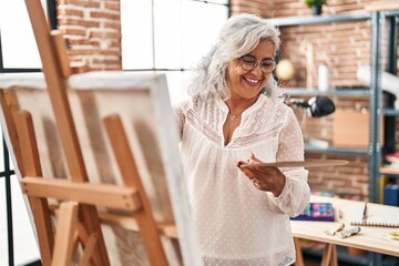 Middle age woman artist smiling confident drawing at art studio