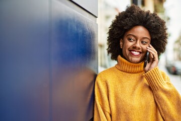 Young african american girl smiling happy talking on the smartphone at the city.