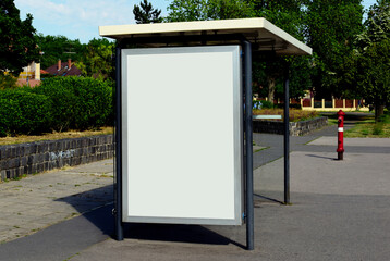 bus shelter at bus stop. image collage of blank white glass and metal structure. urban setting with green background. safety glass design. empty poster ad display. base for mockup. advertising concept