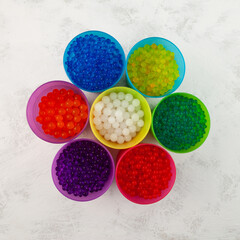 Hydrogel balls or Water beads in plastic cups, top view. Orbeez toy. Flexible gel balls for playing