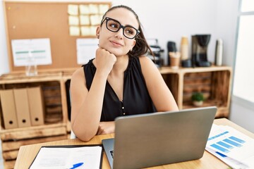 Young hispanic businesswoman smiling happy working at the office.