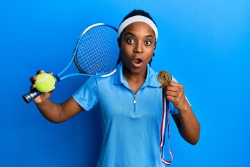 African american woman with braided hair playing tennis holding racket and ball and winner medal...