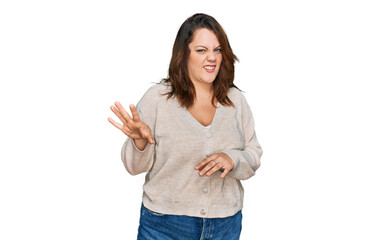 Young plus size woman wearing casual clothes disgusted expression, displeased and fearful doing disgust face because aversion reaction. with hands raised