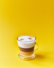  One cup of cappuccino coffee over yellow background