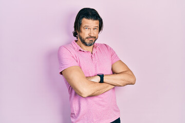 Middle age caucasian man wearing casual white t shirt looking to the side with arms crossed...