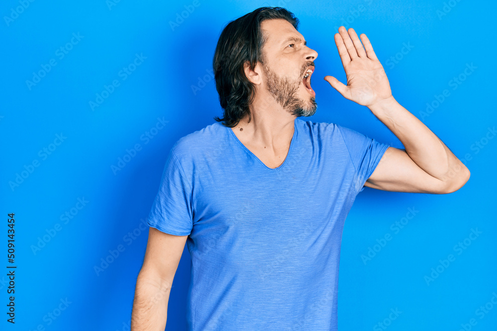 Poster middle age caucasian man wearing casual clothes shouting and screaming loud to side with hand on mou