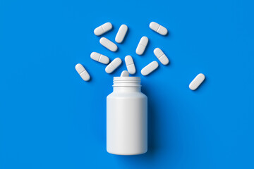 Plastic medical container and white capsule pills on blue background top view. Medicine and health concept. 3d rendering.