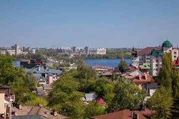 Obraz premium Beautiful view of the city from the observation deck. Little houses. River in the distance. Sunny day. Urban architecture.