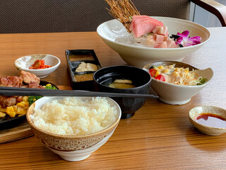 Various menus, sushi, sashimi, nigiri, pan fried pork and miso soup. Sashimi, chutoro sashimi, Japanese food chopsticks and wasabi on the black table, Japanese food style. blurs focus.