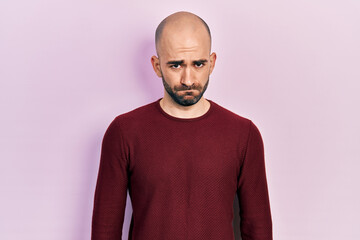 Young bald man wearing casual clothes skeptic and nervous, frowning upset because of problem. negative person.