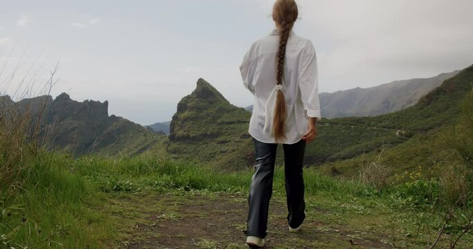 Masca valley,Tenerife. Beautiful young woman tourist raising her arms enjoying the landscape view