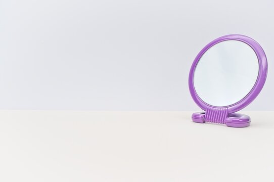 round framed mirror on a bright desk with space for text