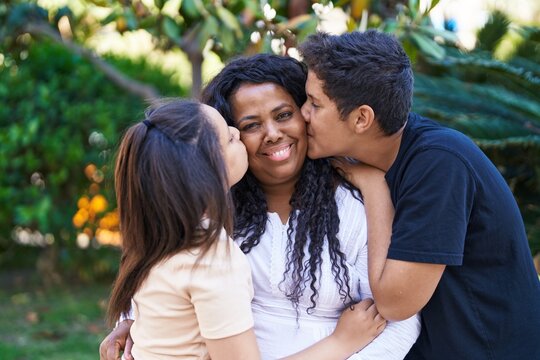 African american family hugging each other kissing at park