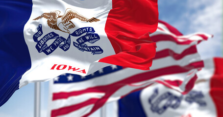 The Iowa state flag waving along with the national flag of the United States of America © rarrarorro