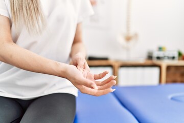 Young chinese woman with pain on hand at clinic