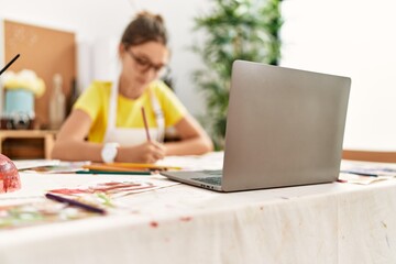 Adorable girl smiling confident having online draw lesson at art studio