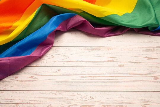 Pride month. Top view of the rainbow flag or LGBT is on a wooden table