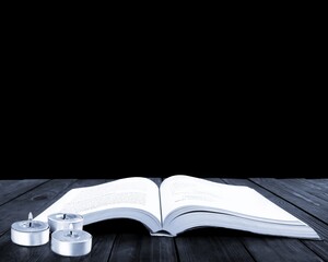 Old book on the dark black wooden desk table space.