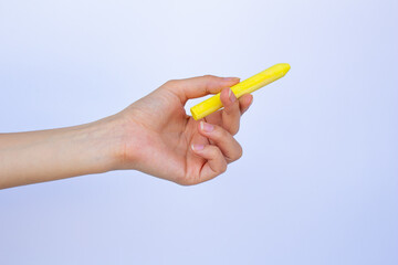 Hand holding yellow chalk isolated on white background.