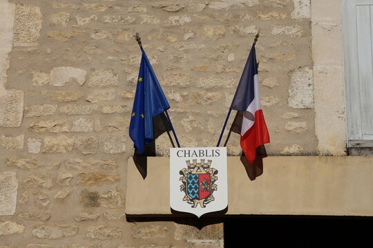Armoiries de la ville de Chablis surmontées d'un drapeau français et d'un drapeau européen, village de Chablis, département de l'Yonne, France