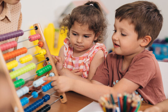 kids in kindergarden learning to calculate on abacus