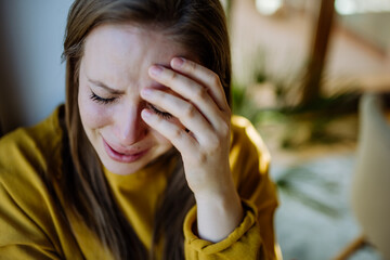 Woman suffering from depression and crying at home.