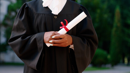 Posing in front of the camera closeup a guy with his diploma taking video details in the graduation day