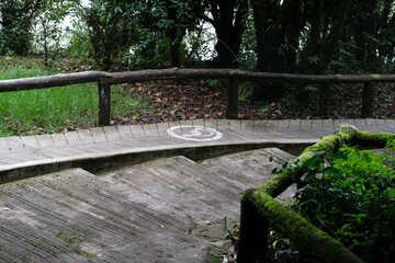 Drawing of a wheelchair symbol on a concrete ramp in a park. Ramps for wheelchairs with sign and wooden railing.