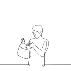 man holding an open bag or package and looking inside - one line drawing vector. the concept of receiving a gift, checking in someone else's bag