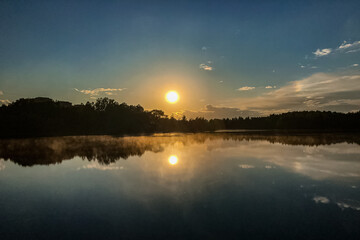 Obraz premium fog over lake water surface at sunset in summer