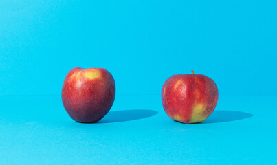 Two apples on blue background. Fruit minimal concept.