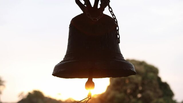 Slider tilt up shot of a old metal church bells at Jesuit missions Bolivia.
