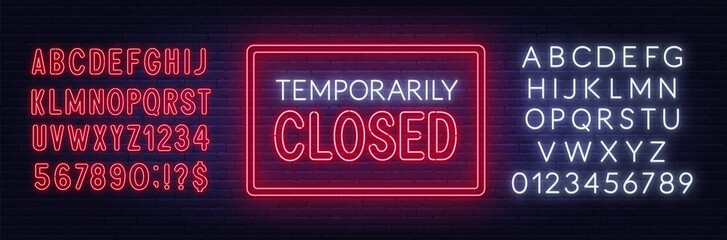 Temporarily closed neon sign on brick wall background.